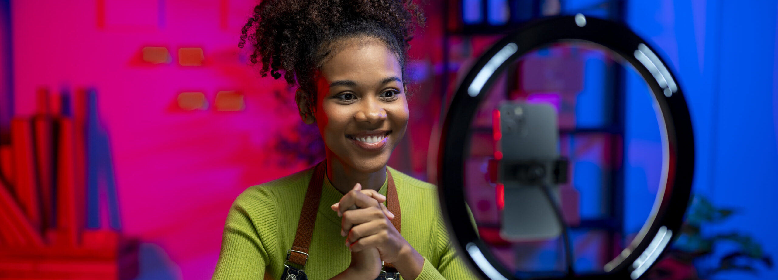 A woman is sitting at a desk with a box in front of her. She is smiling and she is happy